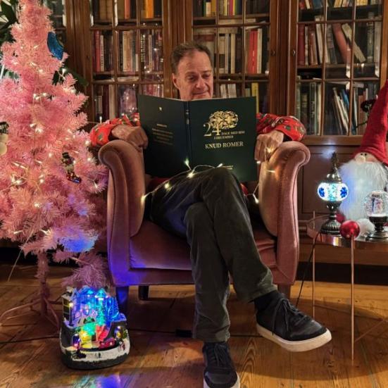 Knud Romer i lænestol, omgivet af julepynt