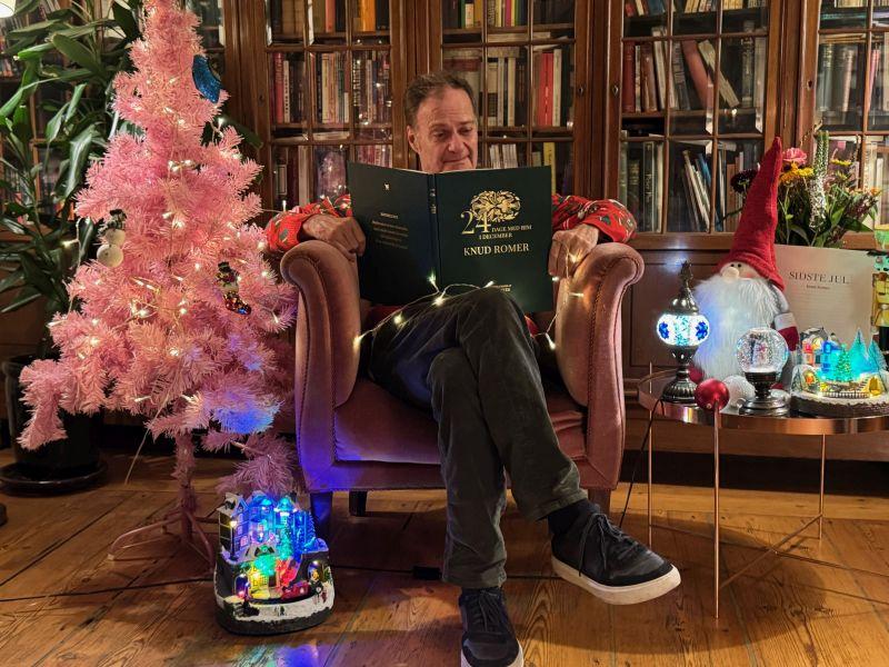 Knud Romer i lænestol, omgivet af julepynt